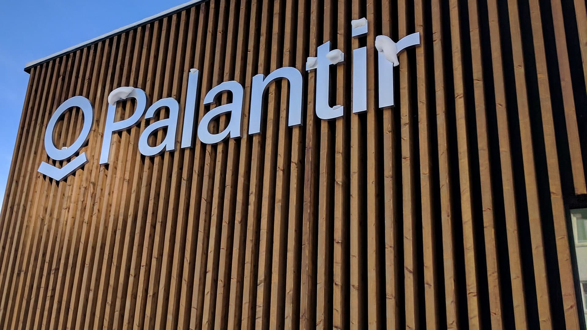 La facciata in legno del padiglione Palantir a Davos, con il logo