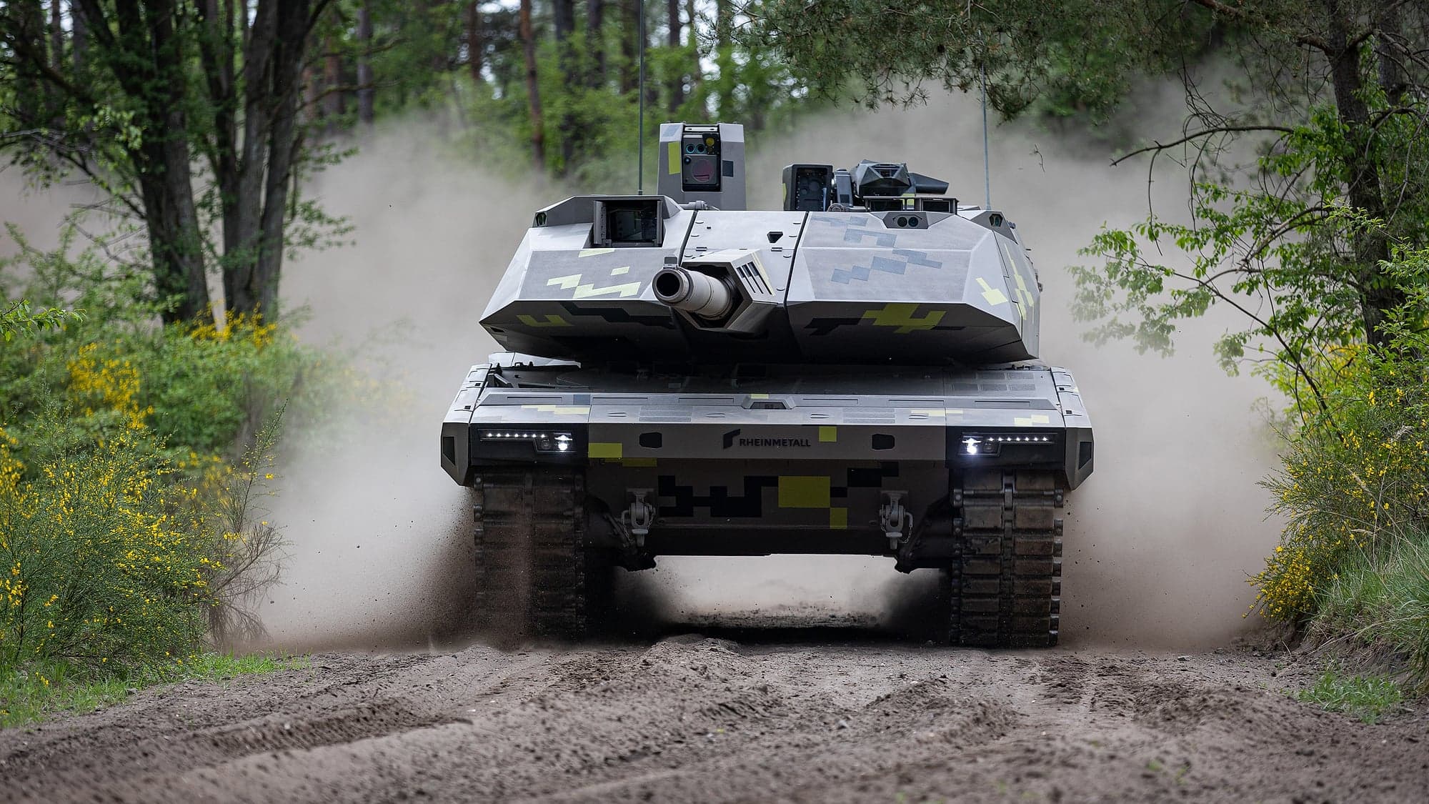 Rheinmetall's Panther KF51 tank advancing along a dirt track, kicking up dust