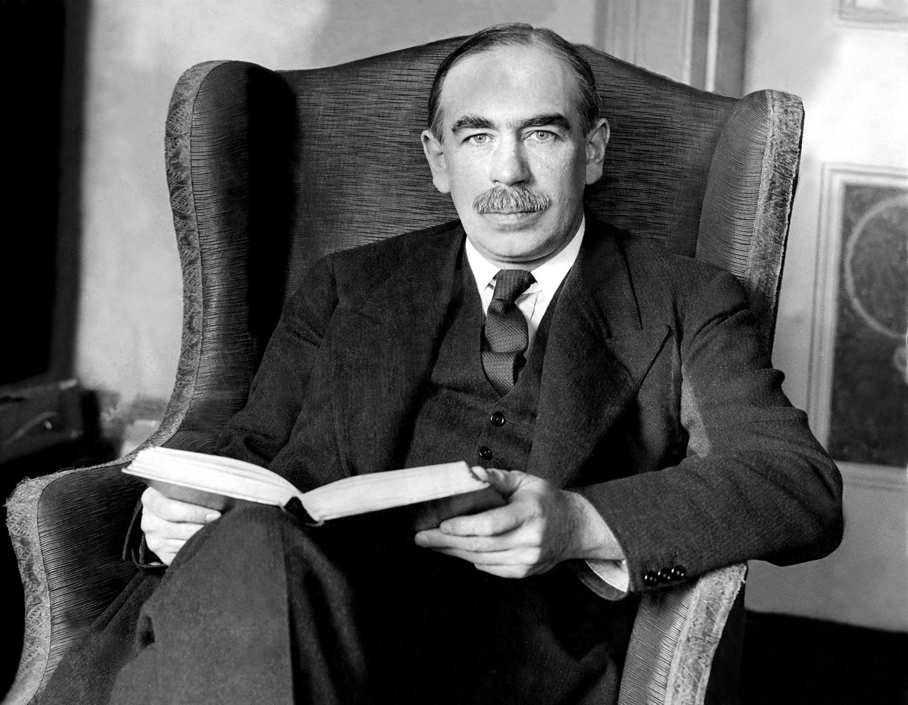 Ritratto di John Maynard Keynes seduto in poltrona con un libro in mano, 1929